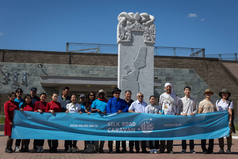 Caravan crew with banner in front of monument